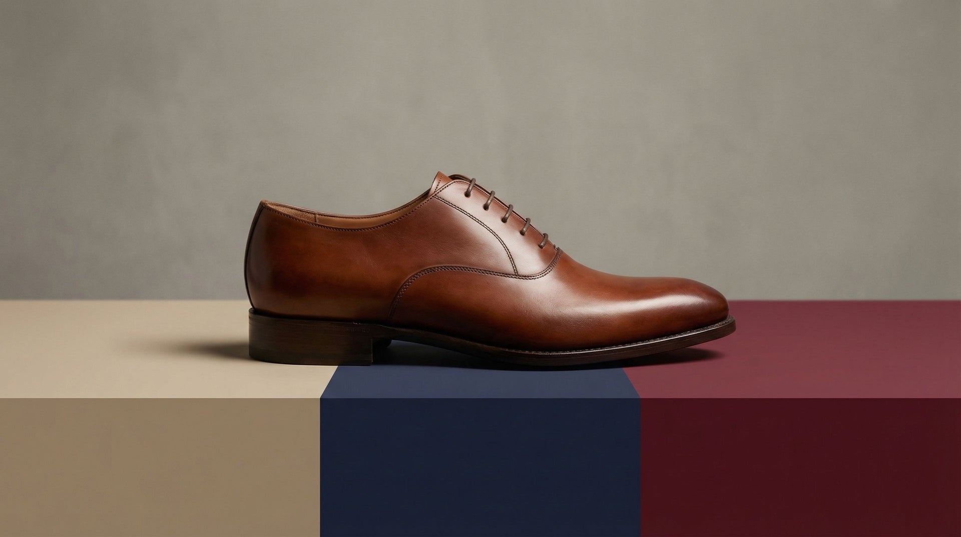 Brown leather dress shoe on a geometric multicolor background